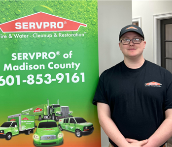Male employee in a black shirt in front of a SERVPRO truck